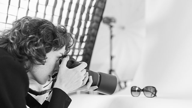 a product photographer takes a picture of sunglasses with her professional camera
